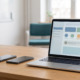 Product team desk with two smartphones and a laptop showing abstract interface blocks